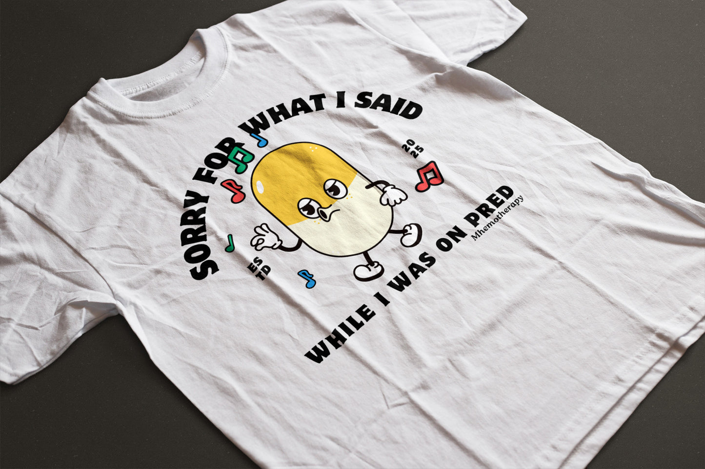 Flat lay view of the white "Sorry For What I Said While I Was On Pred" oddly specific funny cancer t-shirt for men and women by Mhemotherapy.com.