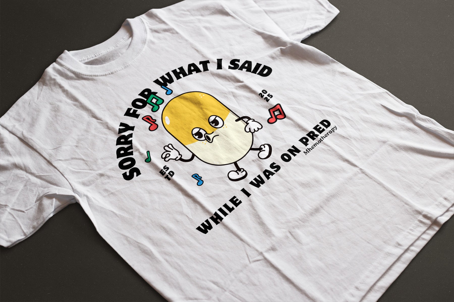 Flat lay view of the white "Sorry For What I Said While I Was On Pred" oddly specific funny cancer t-shirt for men and women by Mhemotherapy.com.